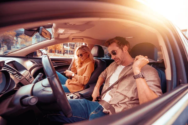 Enjoying road trip together.Leisure, road trip,people and travel concept -man and woman driving in car.