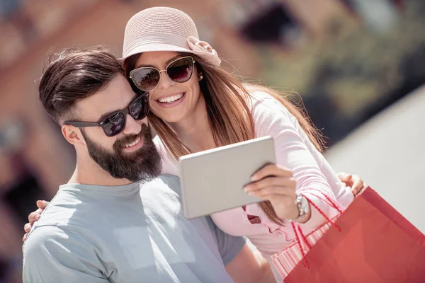 Genç gülümseyen iki alışveriş sonra tablet ile eğleniyor. Dating, aşk ve mutluluk kavramı.
