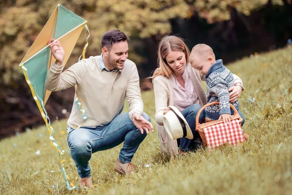 自然の中の幸せな家族の楽しむピクニック 彼らは聞かせてカイトし 一緒に時間を過ごす — ストック写真