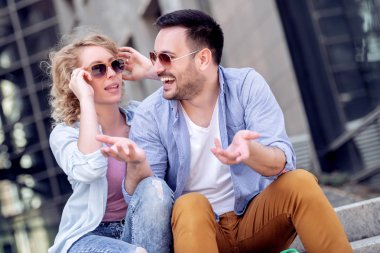 Merdivenlerde oturan ve güneşli günde zevk romantik çift portresi. 