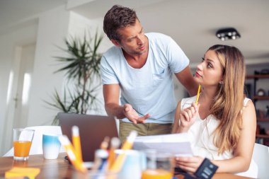 Genç çift evde bütçe hesaplama portresi.