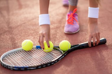 Raket ve top elinde tutan tenis oyuncusu.