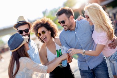 Sahilde bira ile asılı arkadaş grubu.