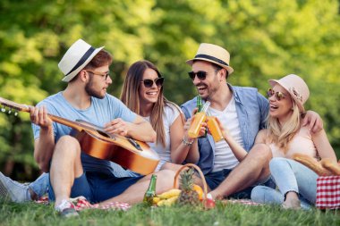 Mutlu arkadaş grubu parkta eğleniyor ve gülümsüyor..