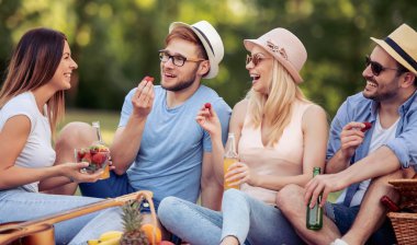 Mutlu arkadaş grubu parkta eğleniyor ve gülümsüyor..