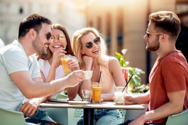 Grup dört arkadaşıyla birlikte bir kahve dükkanında eğleniyor. İki kadın ve iki erkek konuşuyor, gülüyor ve onların zaman zevk Café.