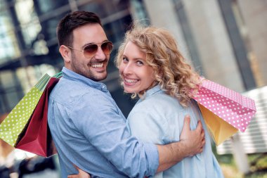 seyahat ve alışveriş konsepti - alışveriş torbalarıyla yürüyen mutlu turistler.