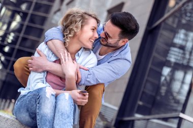 Merdivenlerde oturan çift ve sarılma, yakın çekim.