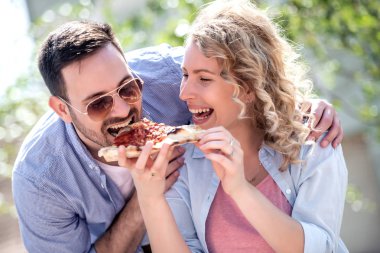 Mutlu çift tr dilim pizza açık havada.