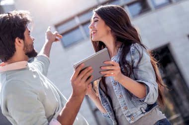 Mutlu çift dijital kullanarak tablet ve şehirde iyi eğlenceler.