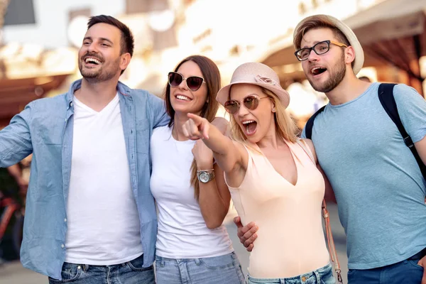 Bir grup genç insan şehirde yürüyüş. Arkadaşlar eğlenmeye açık.