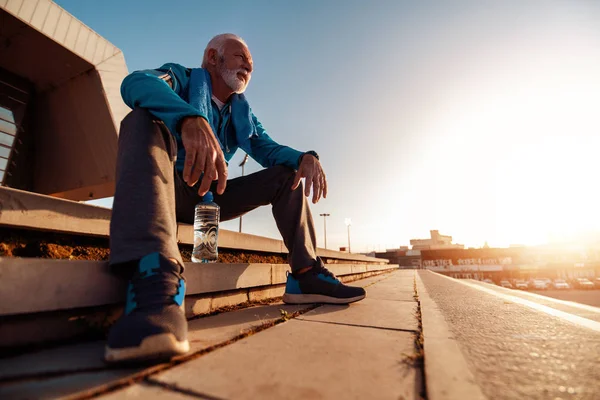 在城里跑步的老人 他在户外锻炼后正在放松 — 图库照片