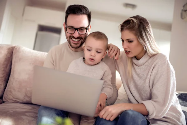 Kanepede Bir Dizüstü Bilgisayar Kullanarak Çizgi Film Izlerken Mutlu Aile — Stok fotoğraf