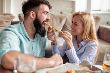 Mutlu çift evde zevk ve pizza yemek.