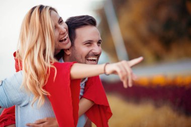 Mutlu genç çift dışarıda eğleniyor ve gülümsüyor..