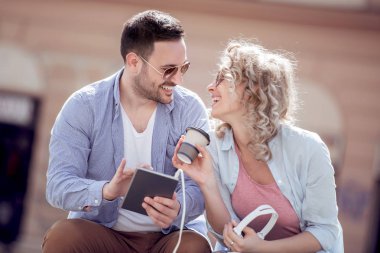 Müzik ve paylaşım mutlu genç çift tablet.
