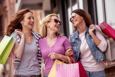 Mutlu arkadaş alışveriş. Üç güzel genç kadın şehirde alışveriş keyfi.