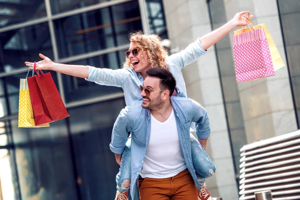 在城市里带着购物袋的一对快乐的年轻夫妇 在一起玩得很开心 — 图库照片