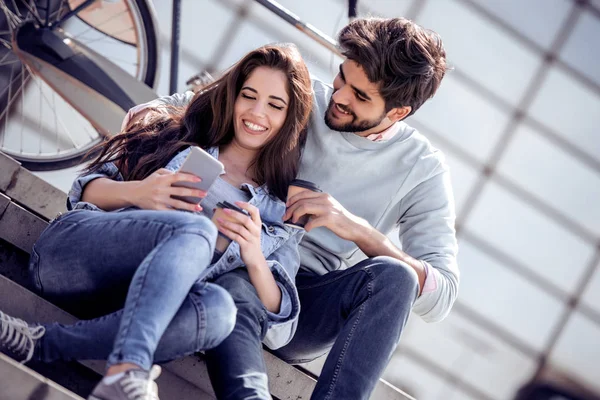 Joven Pareja Sonriente Usando Teléfono Móvil Beber Café Para Mientras — Foto de Stock