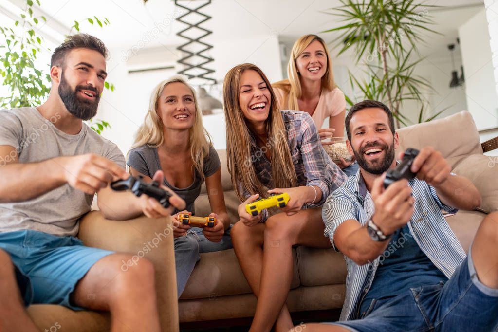 Friends having fun at home,playing video games.