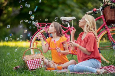 Anne ve kızı parkta eğleniyor.