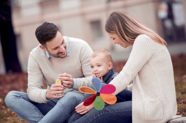 Mutlu üç genç aile birlikte vakit geçirmek ve şehirde otururken gülümseyen.