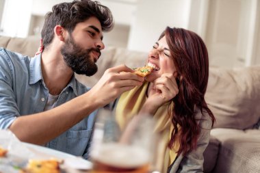 Seven çift evde rahatlatıcı ve pizza yemek. Adam kız arkadaşı beslemeleri.