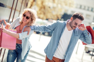 Güzel, genç bir çift alışveriş torbaları taşıyor ve birlikte eğleniyorlar.. 