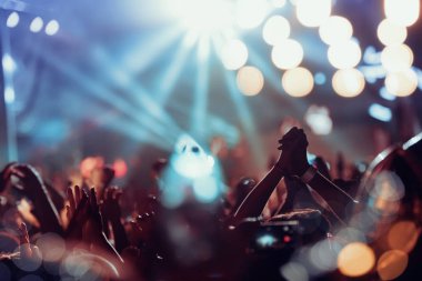 Kalabalık konser. Kalabalığı eğlendirmekten renkli sahne ışıkları önünde.