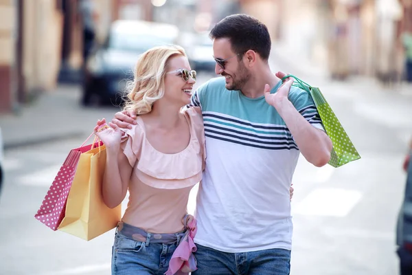 街で買い物をした後のショッピングバッグと幸せなカップルの肖像笑顔と抱擁 — ストック写真