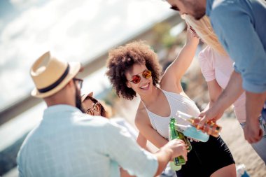 Arkadaş birlikte sahilde zevk, soğuk bira içmek.