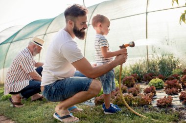 Genç baba ve oğlu bahçede çalışıyor, birlikte eğleniyorlar..
