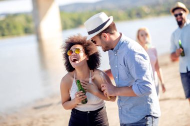 Mutlu erkek ve kız sahilde eğleniyor.