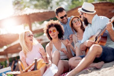 Mutlu arkadaş rahatlatıcı ve sahilde gitar çalmak.