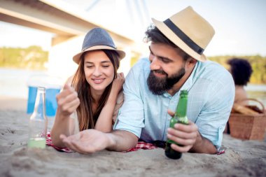 Mutlu çift rahatlatıcı birlikte gülümseyen ve sahilde yalan. Yaz, tatil, tatil ve mutlu insanlar kavramı.