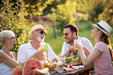 Mutlu aile yaz partisinde öğle yemeği yiyor. İnsanlar, yemek, aşk ve mutluluk konsepti..