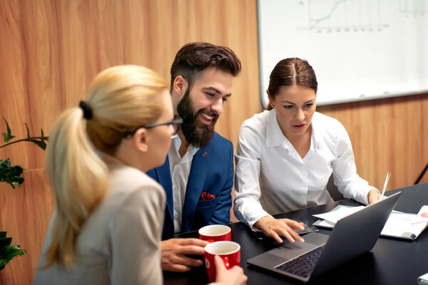 Group of business people meeting to discuss ideas in modern office.