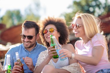 Mutlu grup arkadaşıyla sahilde bira tost ekmegi.