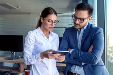 Modern ofiste yeni bir proje üzerinde çalışan iki iş arkadaşı.