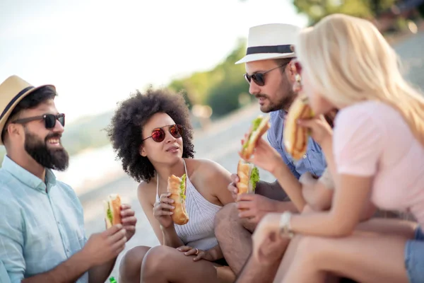 Grupo Jóvenes Comiendo Sándwiches Durante Picnic Playa — Foto de Stock