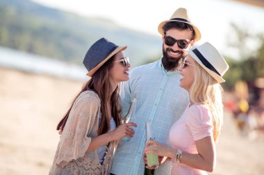 Mutlu genç grup arkadaşıyla sahilde bira tost ekmegi.