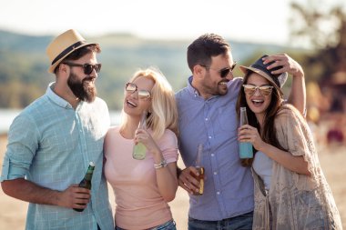 Grup arkadaşıyla sahilde parti. Gençler yaz tatili kutluyor.