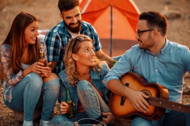 Bir grup insan eğleniyor pikniğe sahilde geceleri.