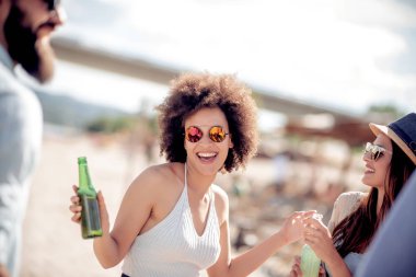 Arkadaş birlikte sahilde zevk, soğuk bira içmek.