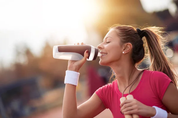 美丽的健身运动员妇女在城市锻炼后喝水 — 图库照片