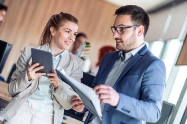 Modern ofiste yeni bir proje üzerinde çalışan iki iş arkadaşı.