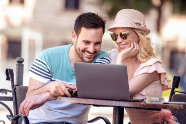 Kafede kalma kadın ve erkek. Birlikte vakit ve dizüstü bilgisayar kullanarak tadını çıkarıyor.