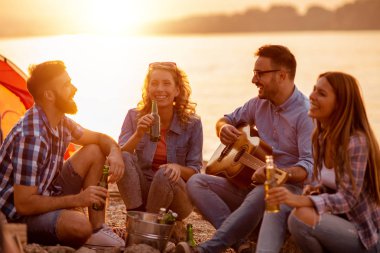 Arkadaşlar gece sahilde müzik keyfi.