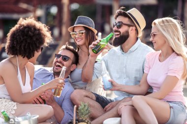Bir grup insan bir iyi ruh hali ve sahilde piknik keyfi. Yaşam tarzı, eğlence, mutluluk ve tatil kavramı.