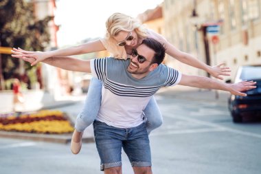 Dışarıda birbirine aşık gülümseyen bir çift. Sokakta sarılan mutlu genç bir çift..